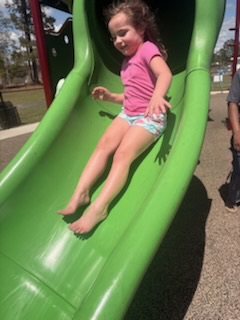 A group of elementary students and staff enjoying a sunny field trip day at a playground and park.