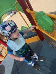 Some students sit together on benches while others climb and explore. 
