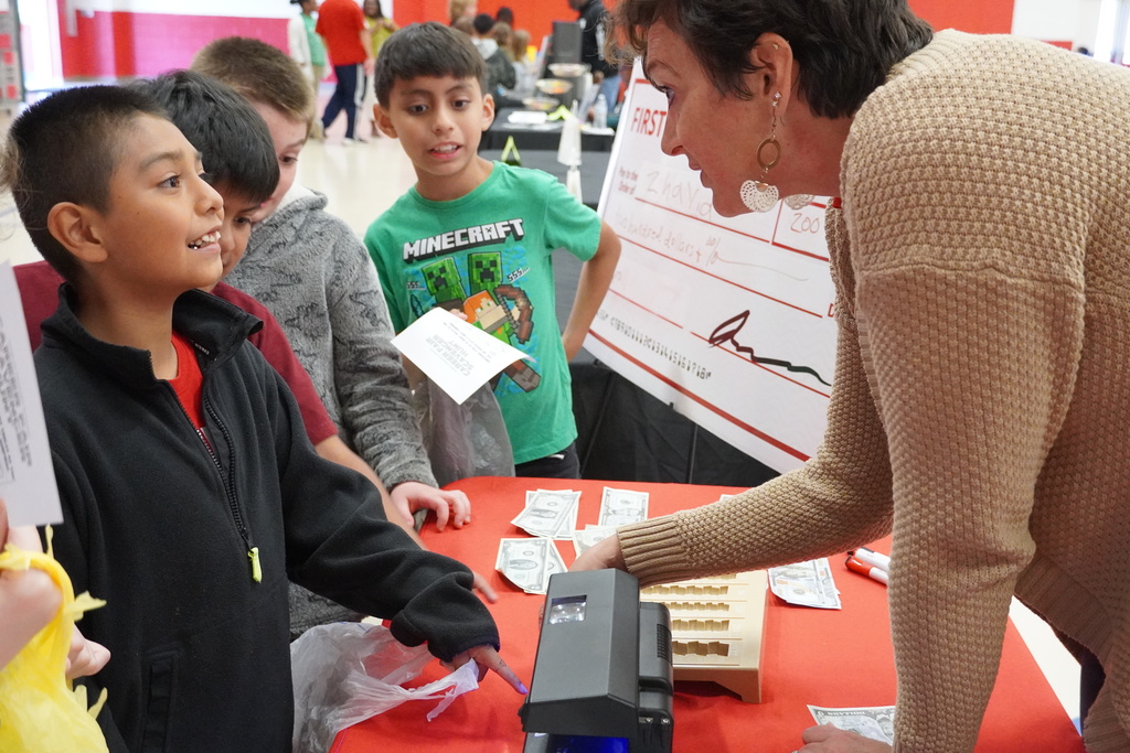 An adult is talking with an excited student about the profession of banking.