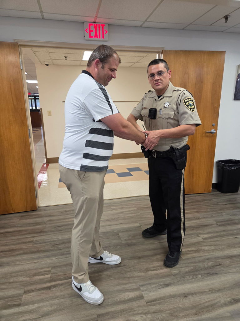 West Bladen Principal Mr. Orrock stands with a law enforcement officer in the school hallway during the annual Jail-A-Thon fundraiser.