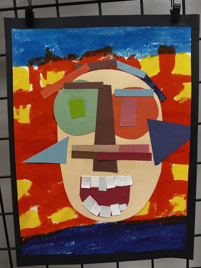 Cubist-inspired paper collage artwork of an abstract face on a large beige oval head with a mottled blue sky background and vibrant red and yellow ground. The face features large irregular circle eyes in green and orange with colored rectangle pupils, brown eyebrows, a dark brown vertical nose strip, a deep red U-shaped mouth with white paper teeth, and various colored paper strips for hair and facial details.