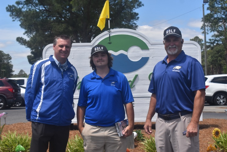 principal of East Bladen, Senior Levi Harrelson, and golf coach Jeff Huff standing in front of a golf course sign 