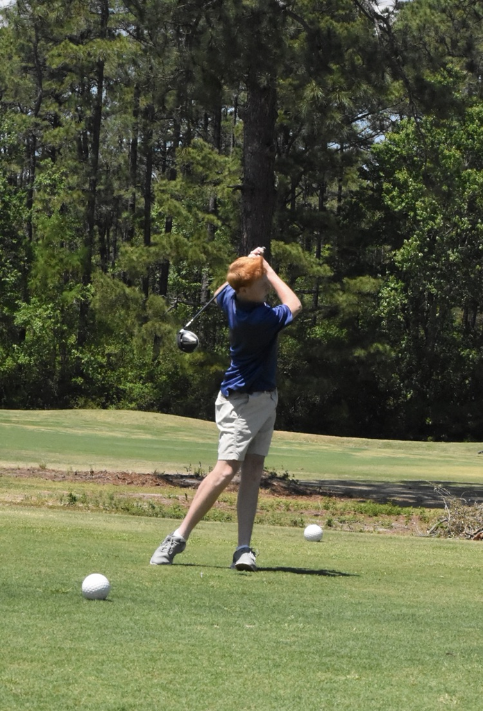 studying candy shorts with blue shirt swinging to hit a softball