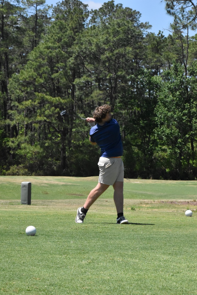 studying candy shorts with blue shirt swinging to hit a softball