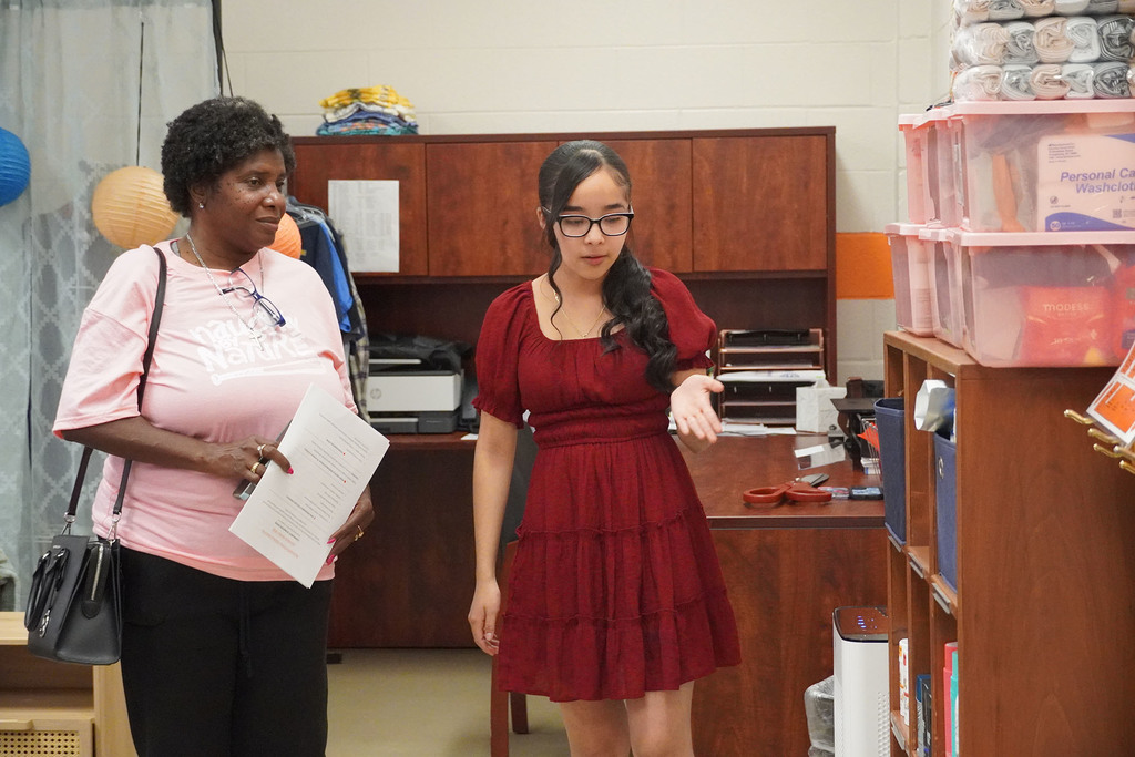 A student is talking with an adult about supplies.
