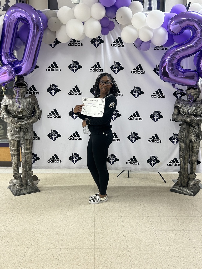 A student poses in front of the Decision Day backdrop, holding an “I Decided!” certificate and smiling. Purple and white balloons and large “2026” balloon numbers frame the display.