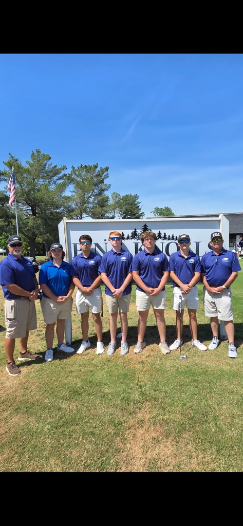 seven guys in khaki pants, blue polos with golf clubs, sunny day in front of a sign at a golf course