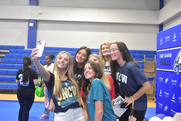 a group of 6 students pose as they take a selfie