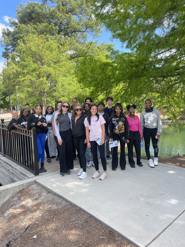 Group of students in front of a pond on a bridge.