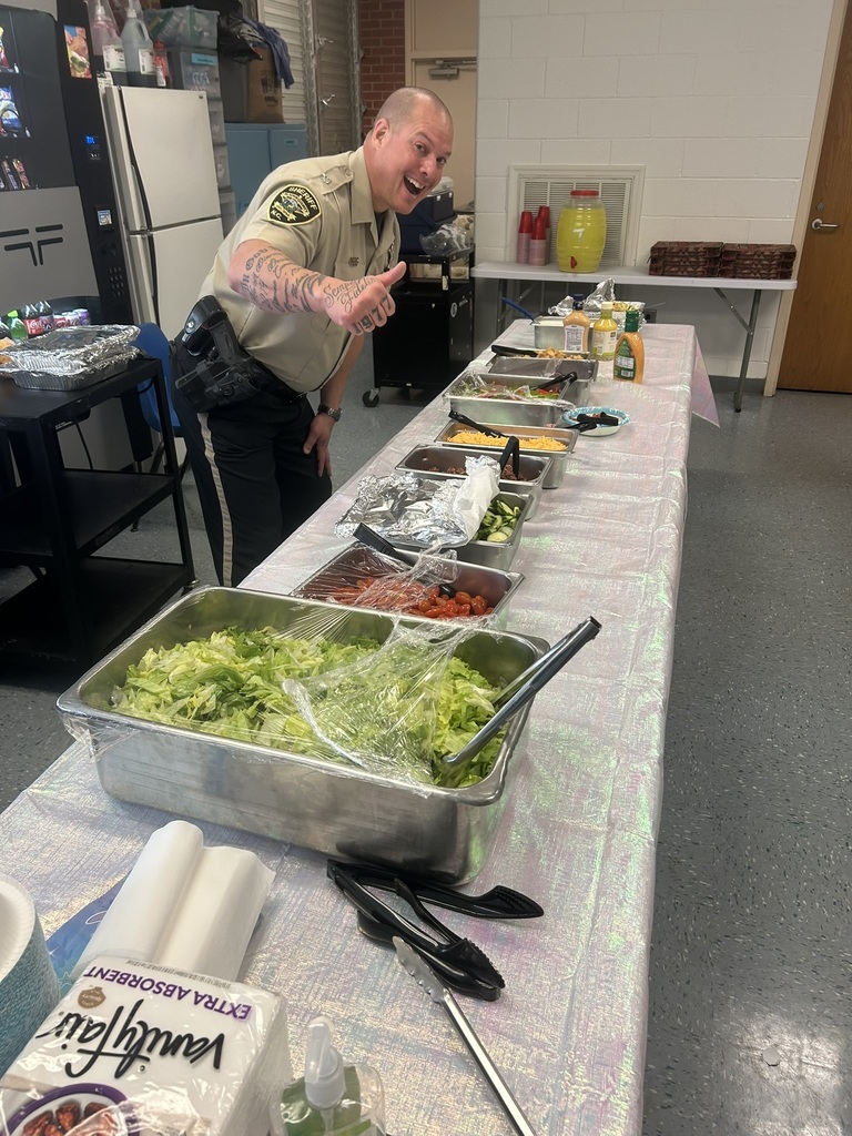 A long table filled with salad bar items, pasta salad, dressings, toppings, and fresh vegetables is prepared for teachers during Teacher Appreciation Week.
