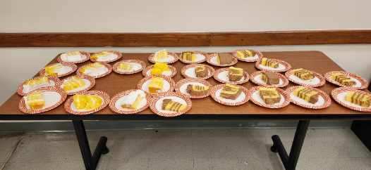 Individual dessert plates with assorted cake slices and treats are arranged on a table for ETMS staff during Teacher Appreciation Week.