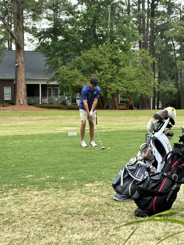 Henry Simmons works on putting practice on the golf course  