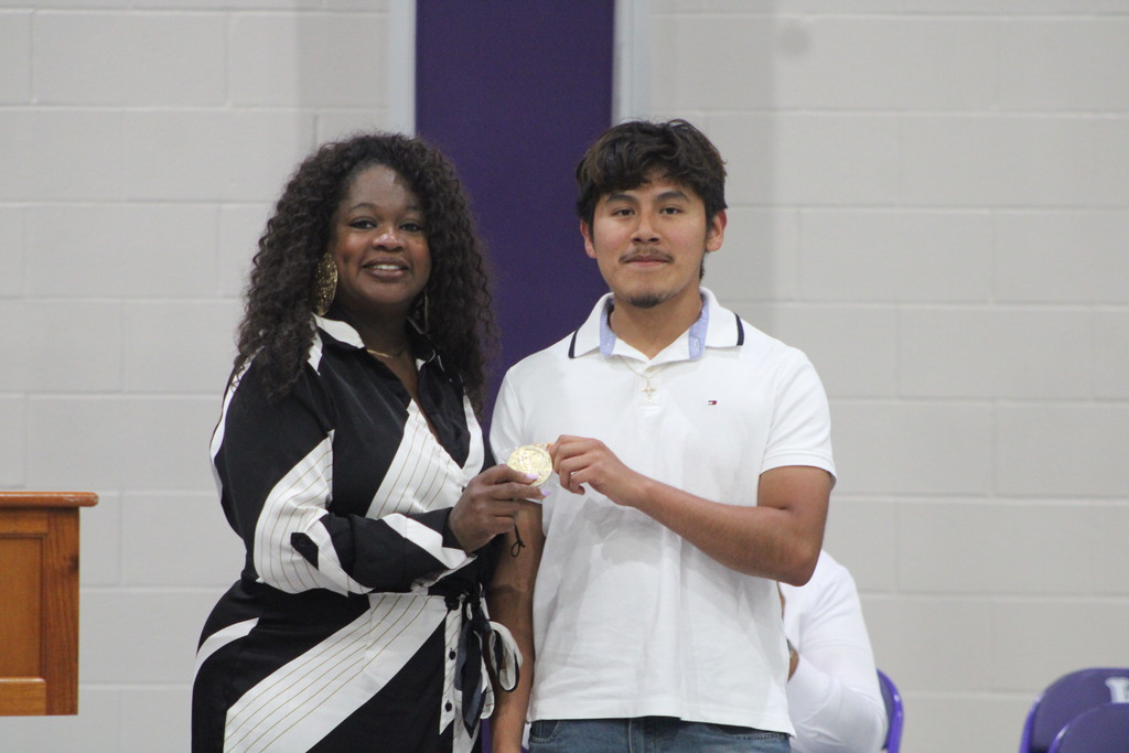 A student and school administrator pose together while displaying a medal during West Bladen High School’s Scholastic Awards and Scholarship Night.