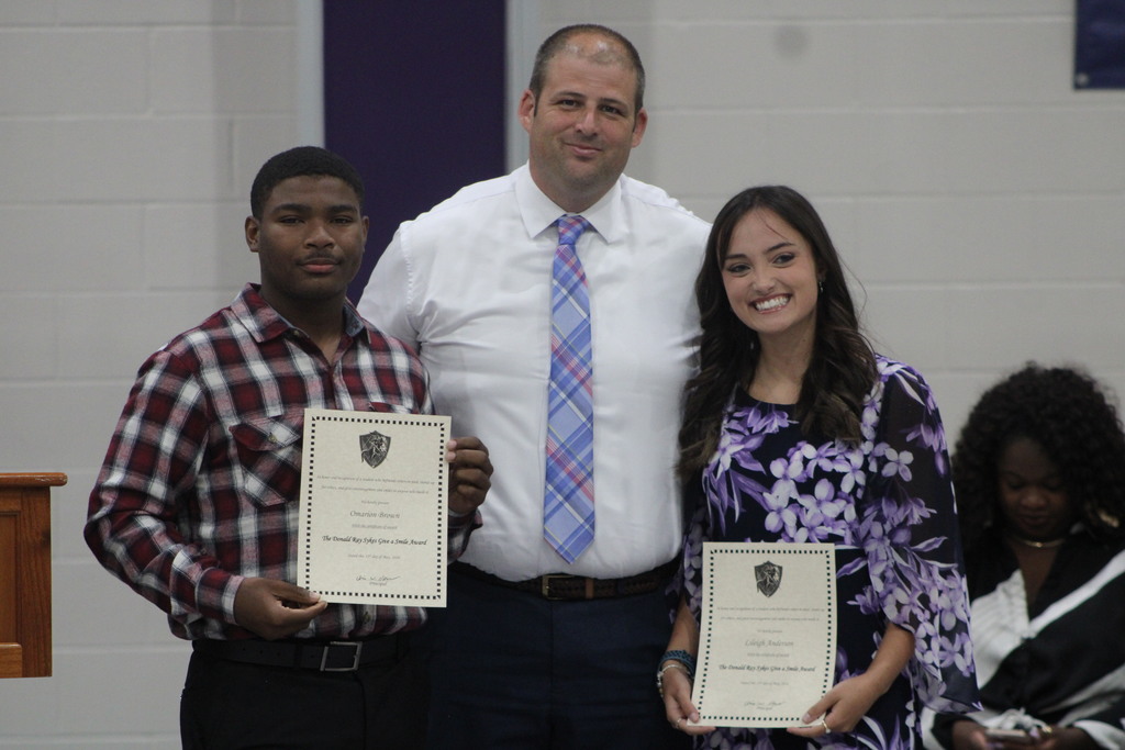 Two students pose with the school principal while holding award certificates during West Bladen High School’s Scholastic Awards and Scholarship Night.