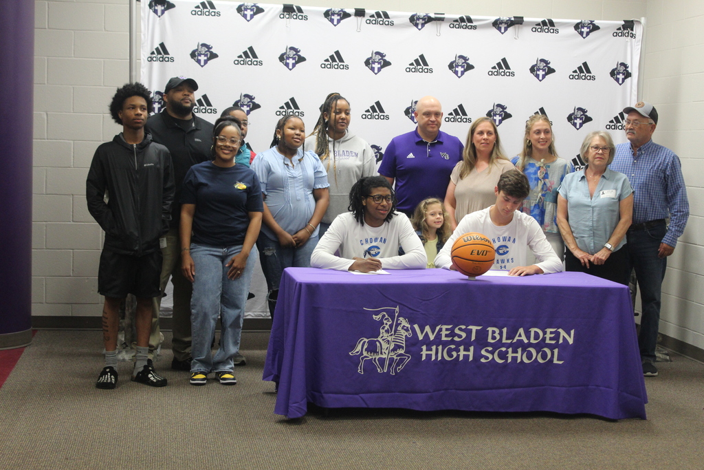 Family members gather behind Jackson Pait and Tylik McCall during their Chowan University basketball signing ceremony at West Bladen High School.