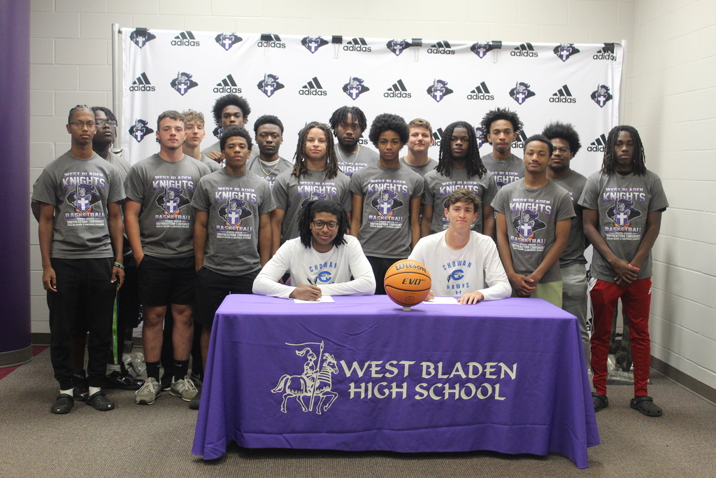 Members of the West Bladen basketball team stand behind Jackson Pait and Tylik McCall as the two student-athletes sign to play basketball at Chowan University.