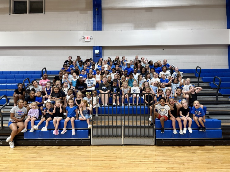 large group of young girls sitting on bleachers for cheer camp at East Bladen making funny faces