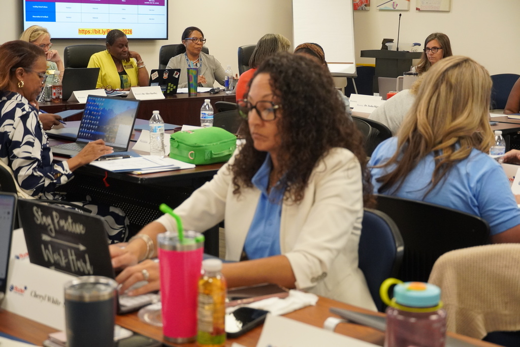 District leaders learning together in a large room.