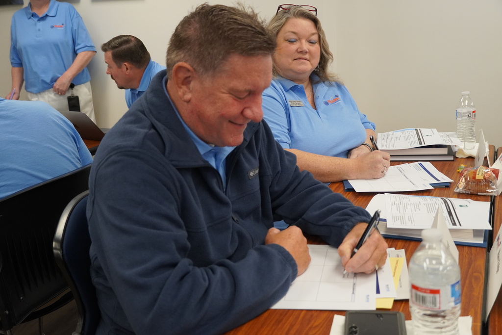 District leaders smiling and working together at a desk.