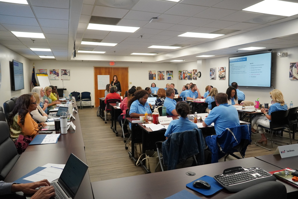 District leaders learning together in a large room.