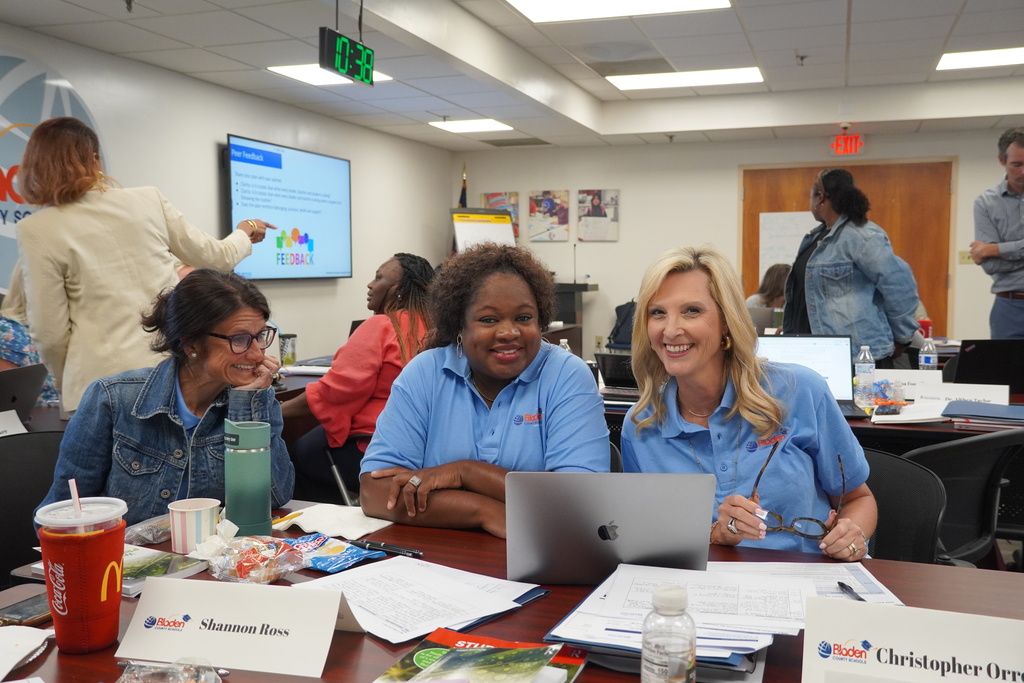 District leaders working together and smiling at a desk. 