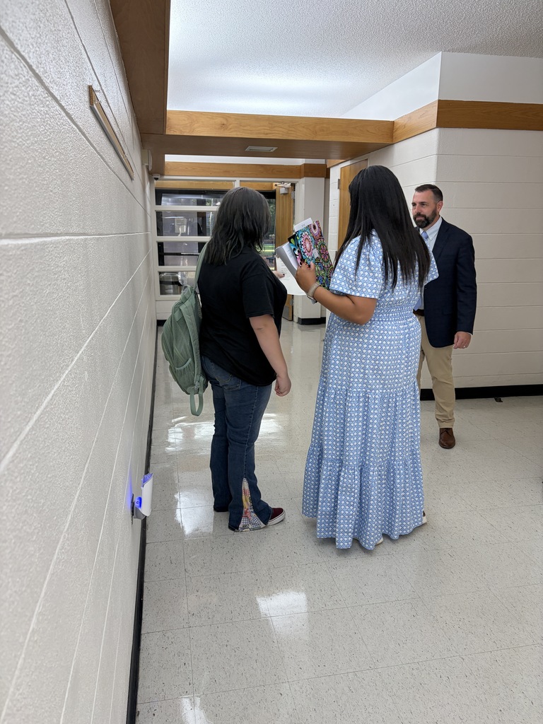 Staff are seen helping a student in the hallway.