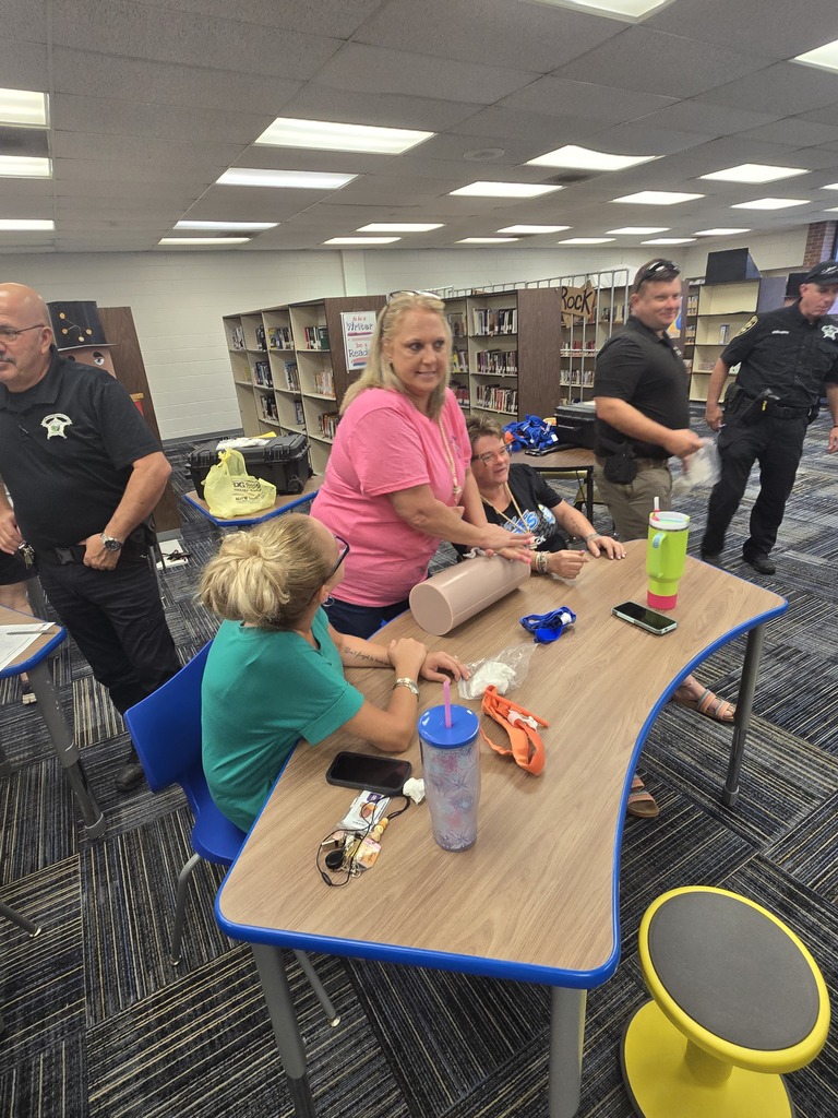 BMS staff members practice applying direct pressure and other bleeding-control techniques on a training model during Stop the Bleed training with instructors nearby.