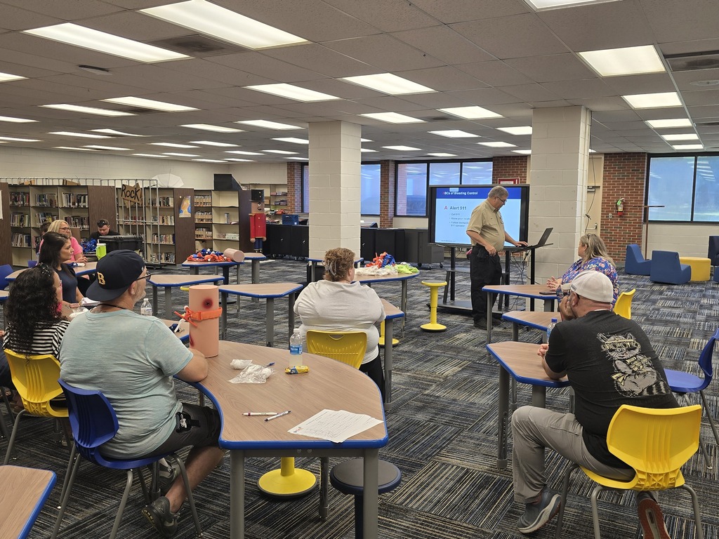 BMS staff members participate in Stop the Bleed training as an instructor presents emergency bleeding-control procedures and demonstrates steps for responding to a life-threatening injury.