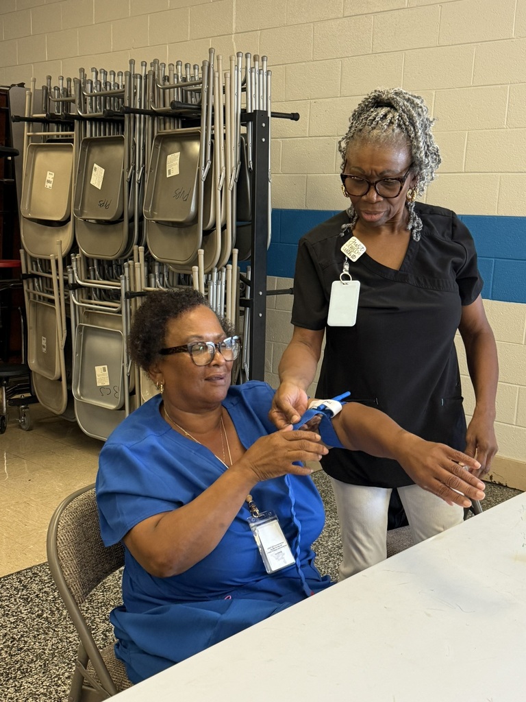 An EPS staff member practices applying a tourniquet to a colleague’s arm during Stop the Bleed emergency response training