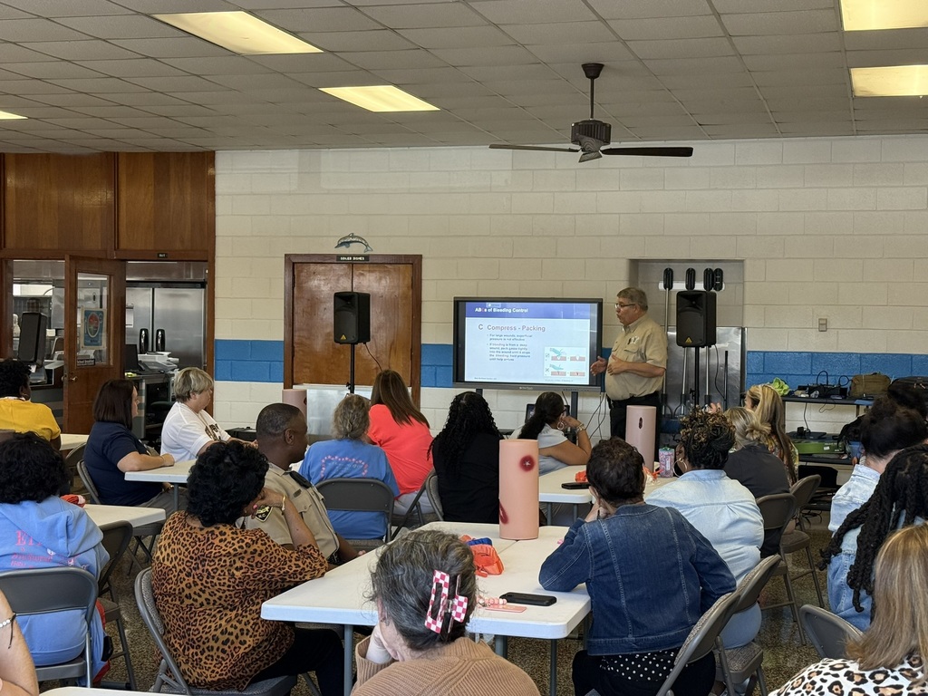 Elizabethtown Primary School staff members participate in Stop the Bleed training while an instructor presents information about controlling severe bleeding.