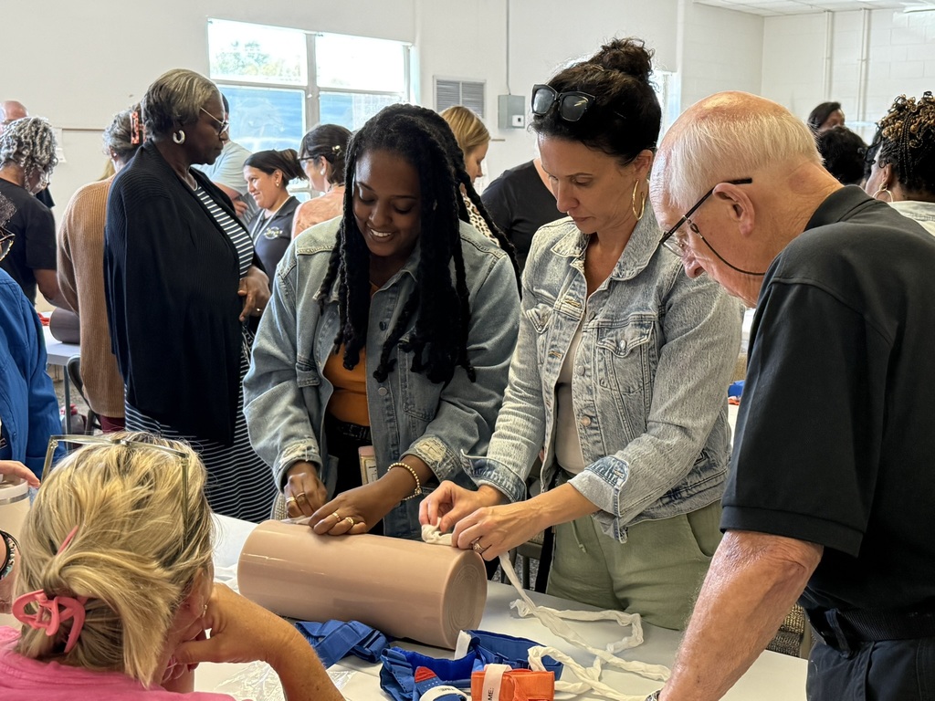 EPS staff members practice wound-packing techniques on a training model as part of Stop the Bleed training.