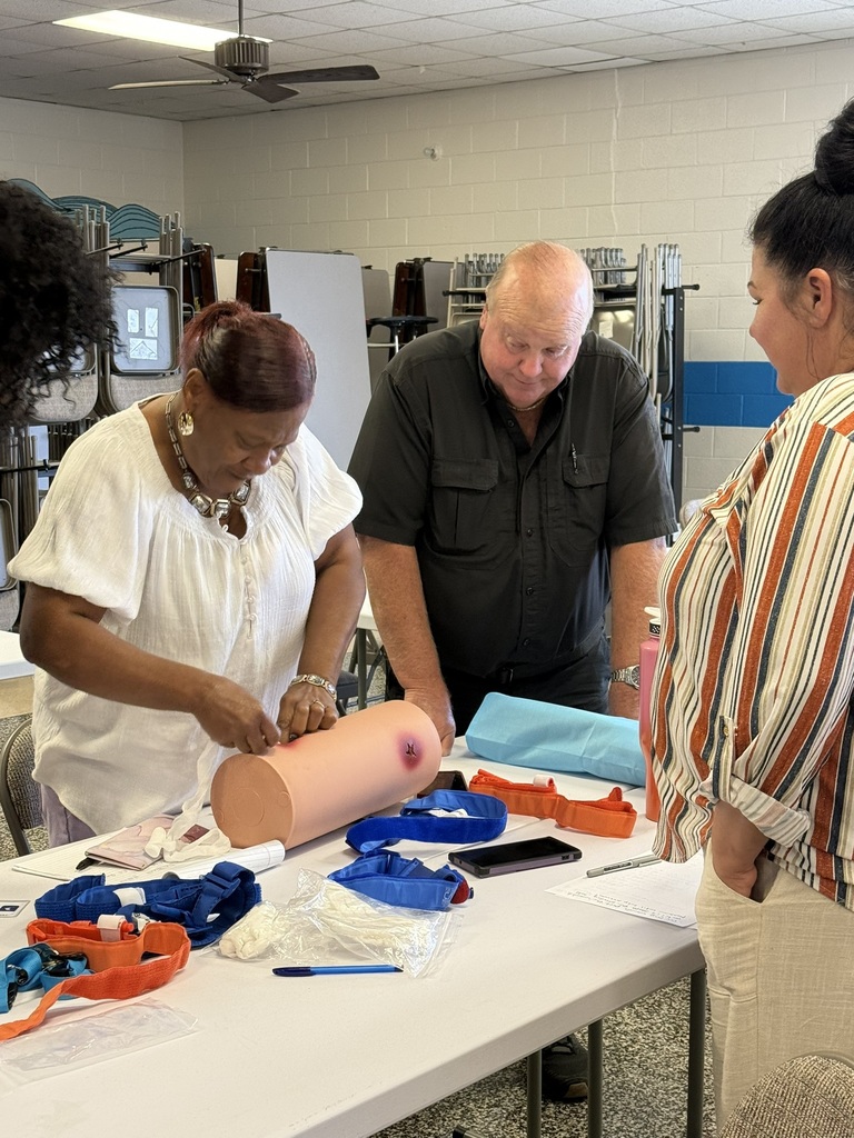 EPS staff members practice wound-packing techniques on a training model as part of Stop the Bleed training.