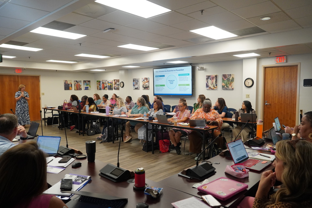 School administrators, counselors, and social workers and listening to a presentation.