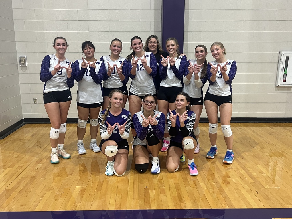 Varsity Volleyball team along with Coach Rhodes after their win against Pender.