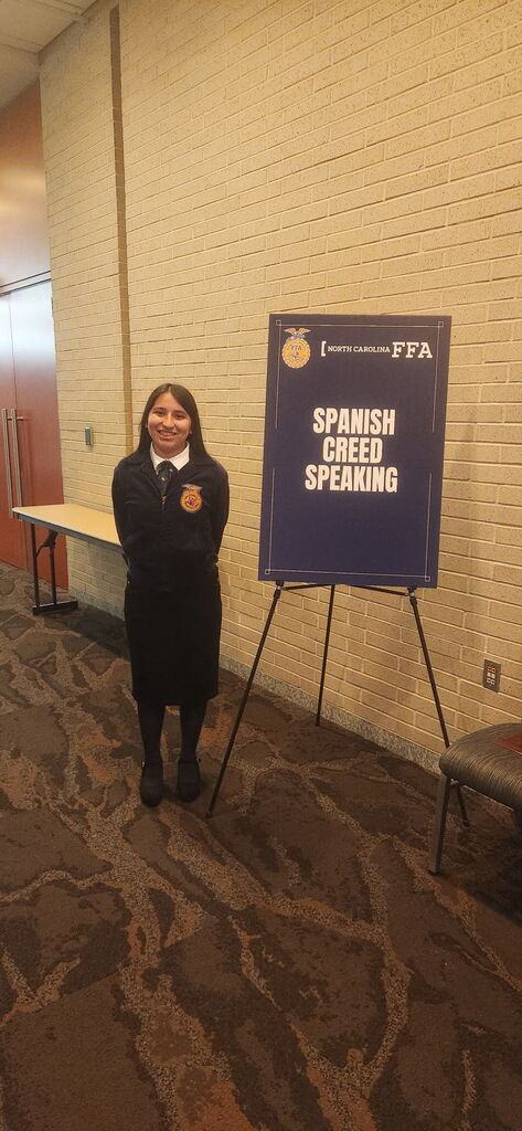 Student haveinv their photo taken in front of a sign for the Spanish ffa creed competition 