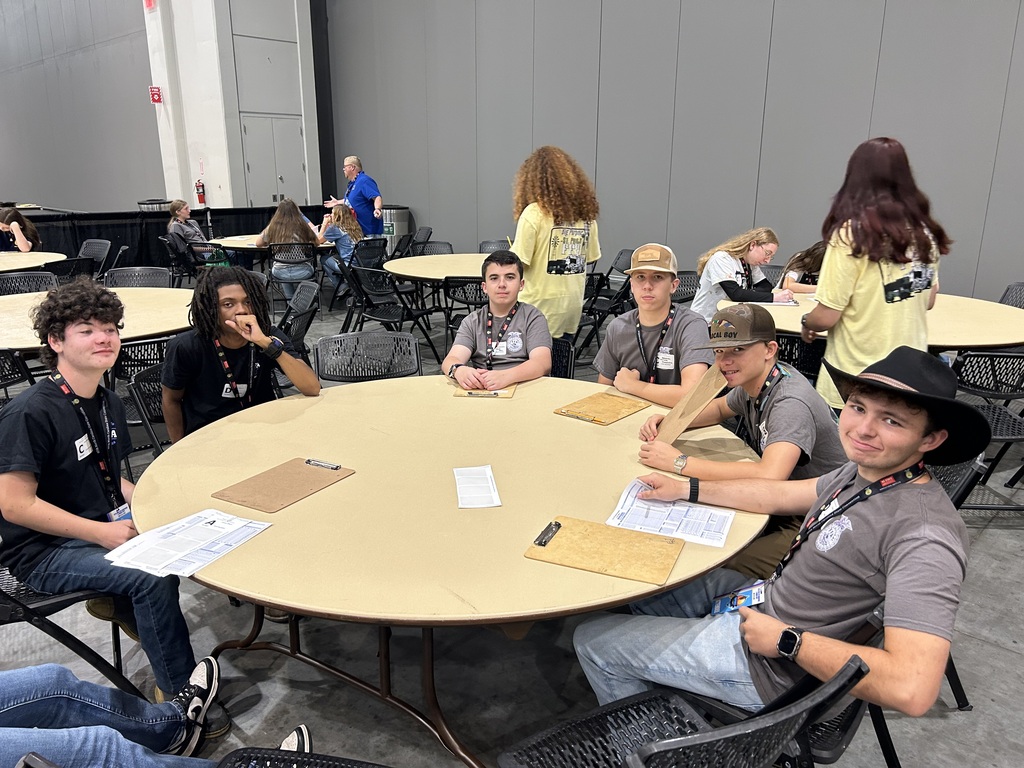 Students having their photo taken at a table.