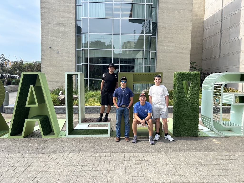 Students having their photo taken in front of a building.
