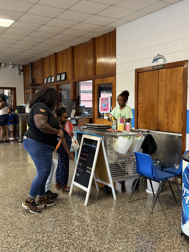     Families visit a colorful slush and refreshment station set up inside the cafeteria during Open House.