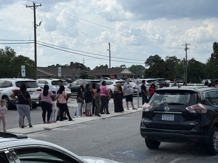     Families and students line the sidewalk and parking area outside Elizabethtown Primary School during a busy Open House.