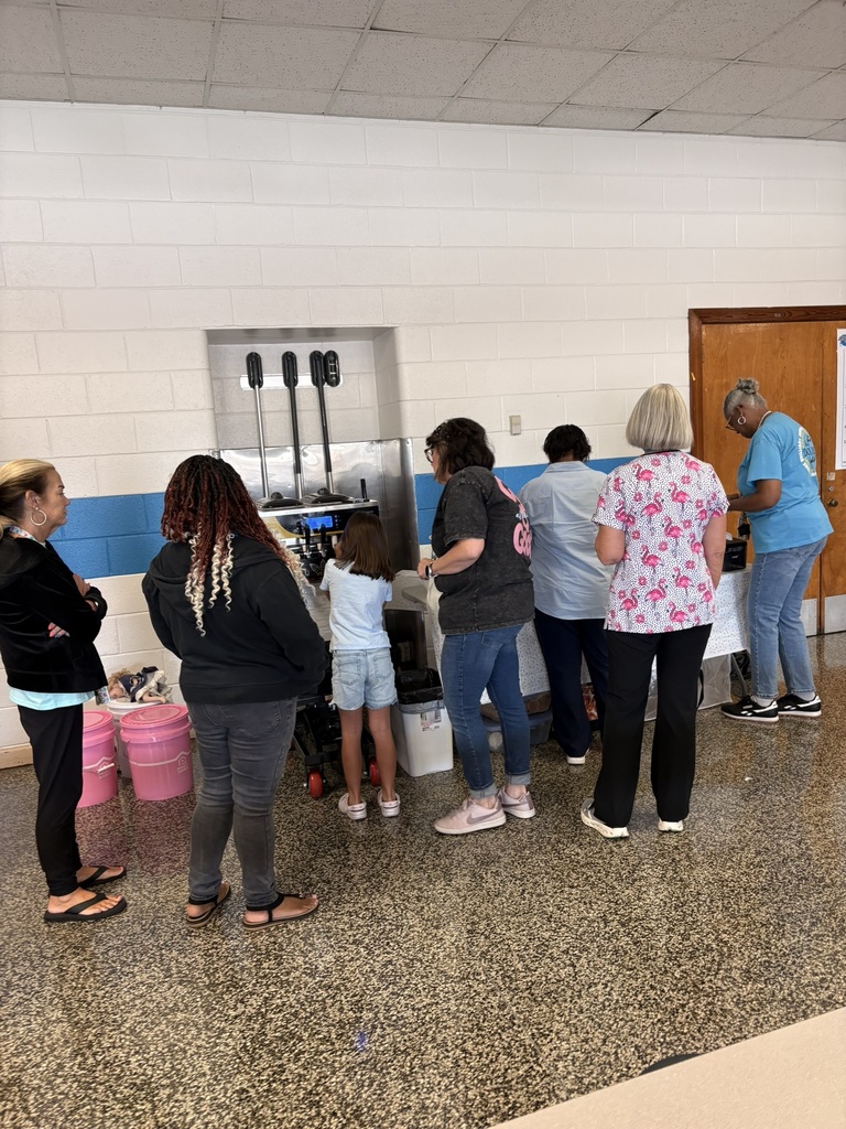 EPS staff members gather around an ice cream station, choosing sweet treats and toppings during the final staff workday before students return.