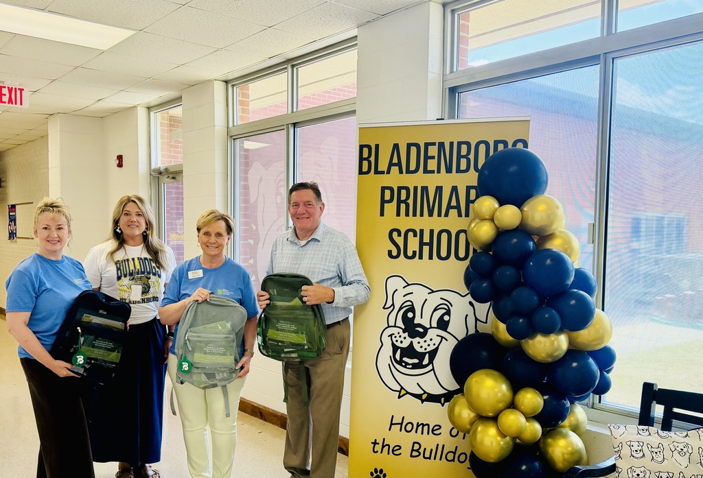 Bladenboro Middle Staff are smiling with staff from BCC holding bookbags.