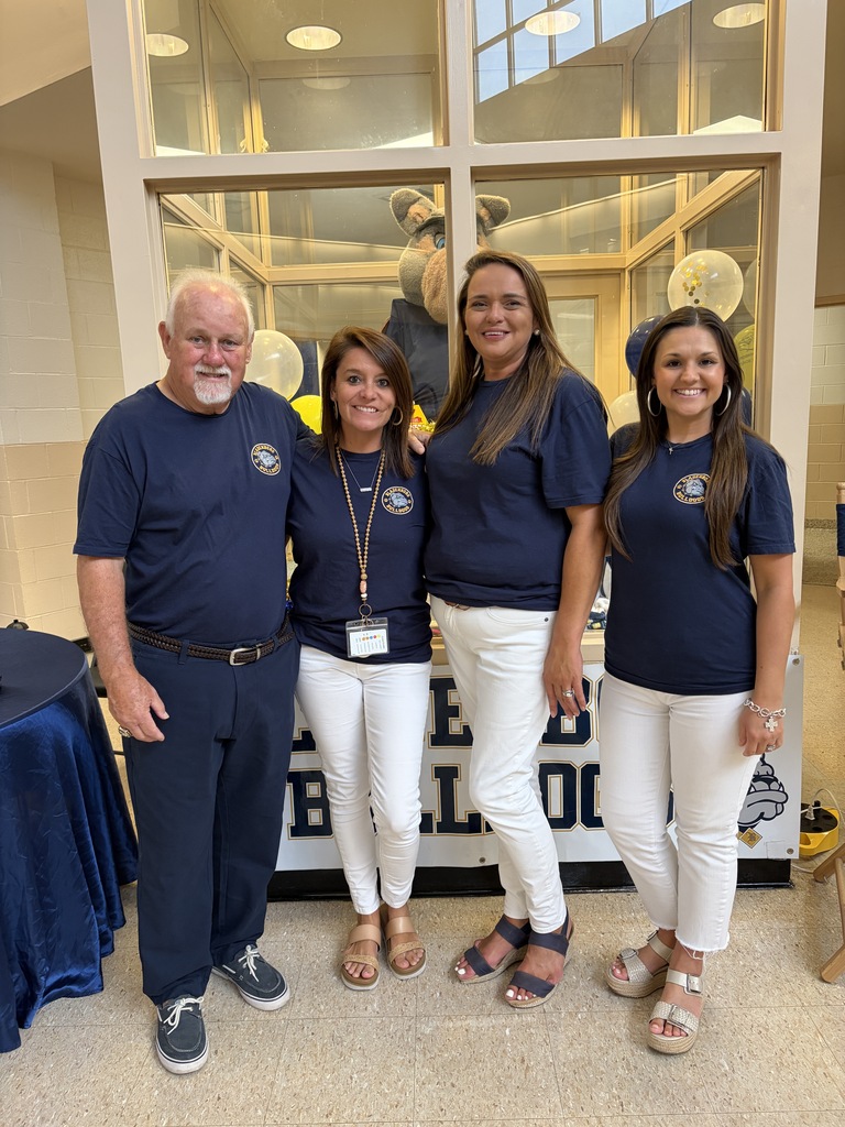 Bladenboro Middle School staff members stand smiling together in the entryway. 