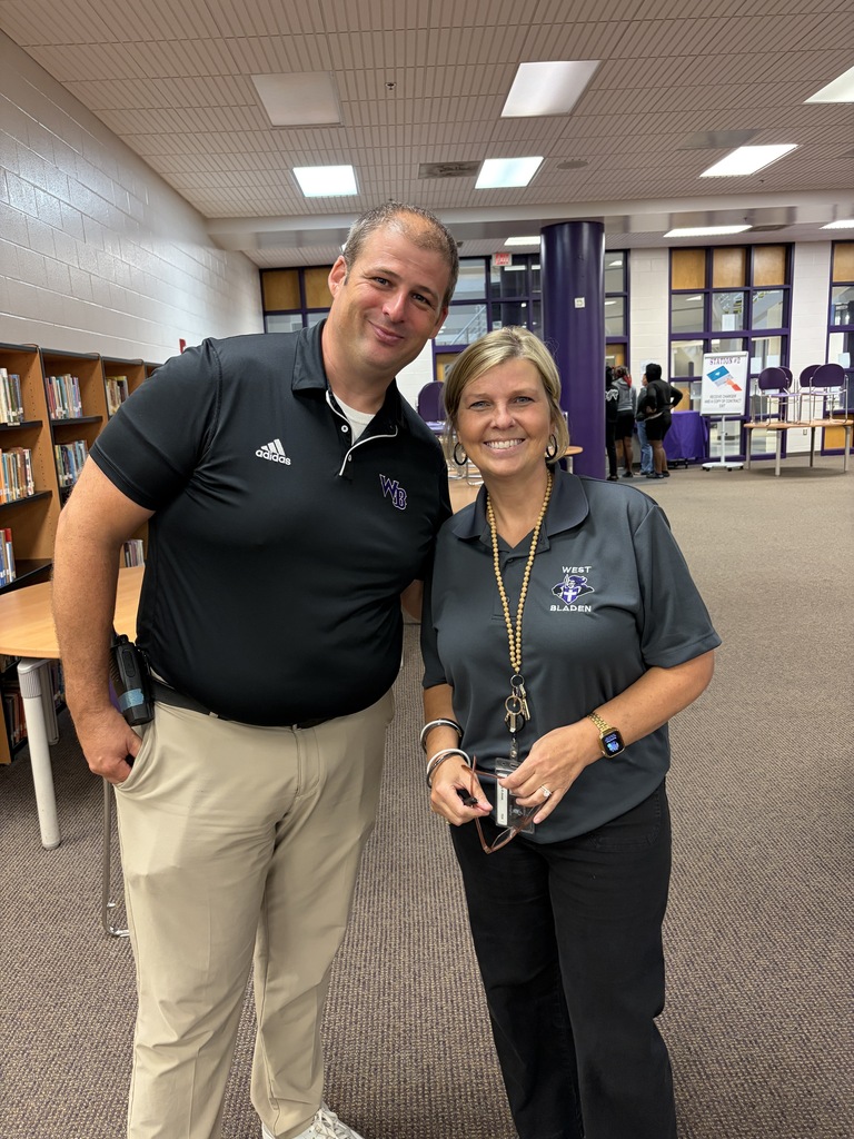 An administrator and teacher are smiling in the West Bladen media center.