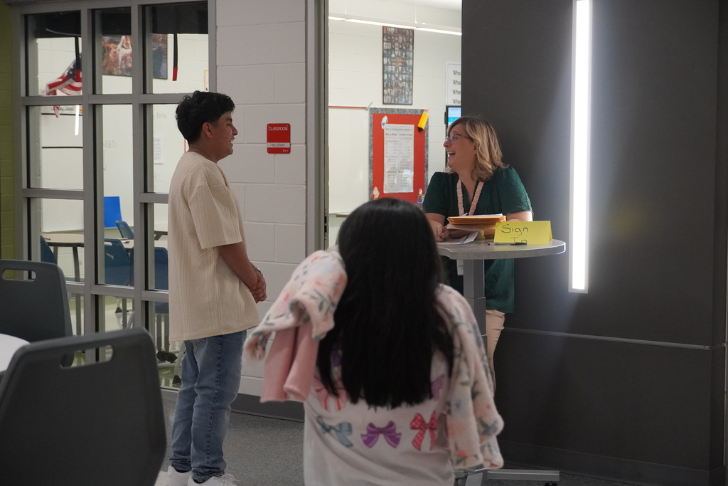 A student and teacher are chatting at open house.