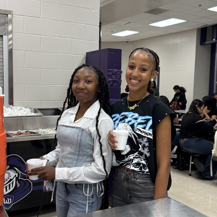 2 female students smiling in the cafeteria 