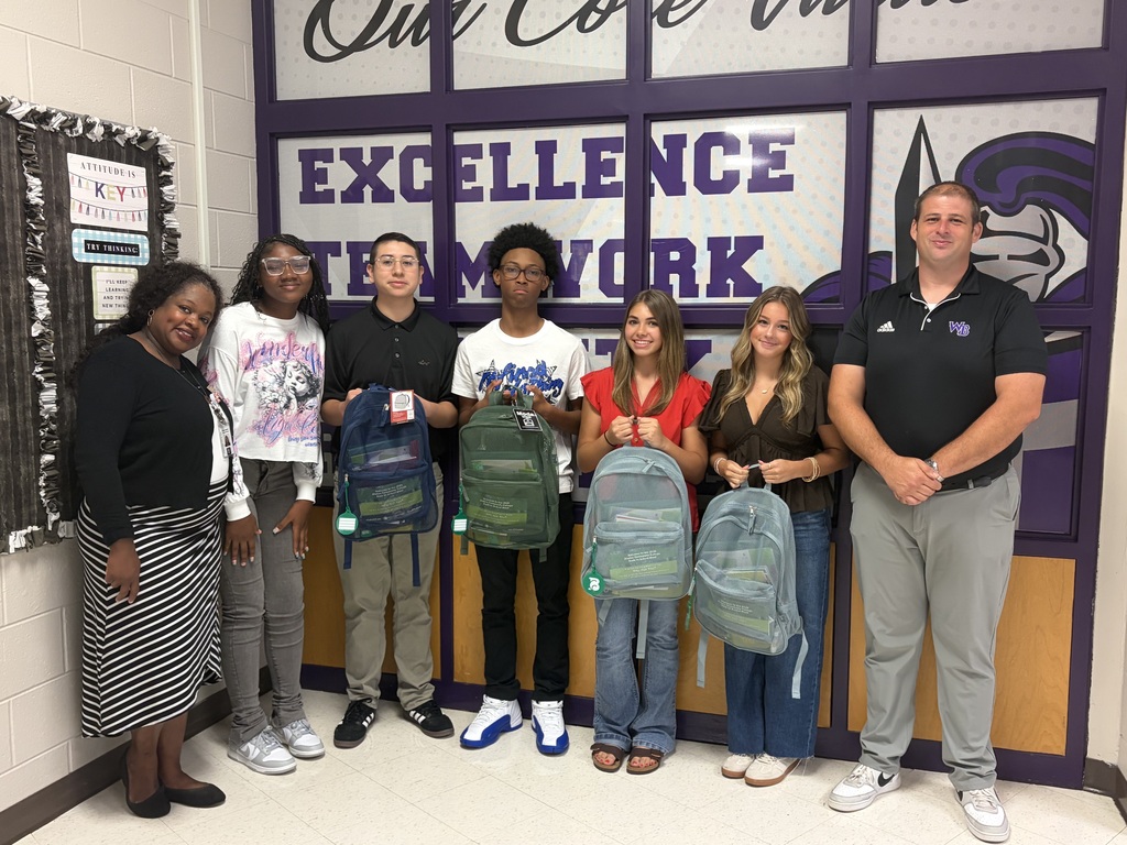 Students and administration holding donated backpacks