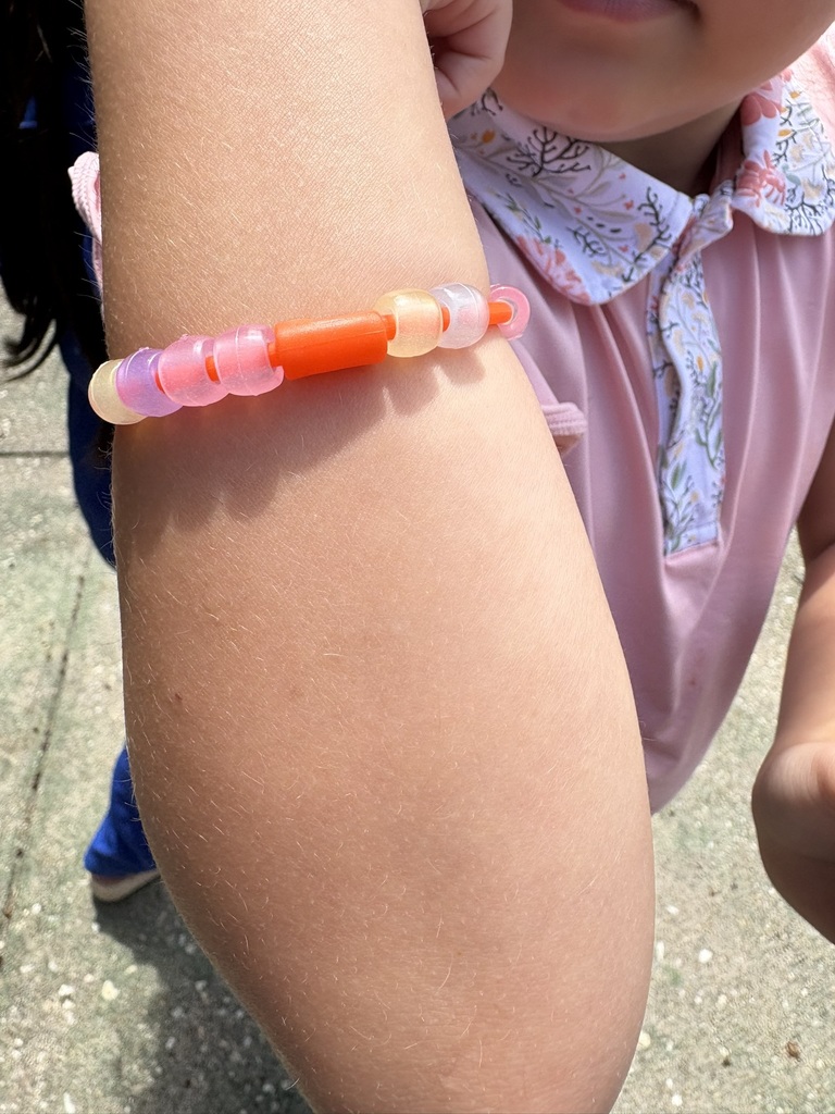 Student wears a bracelet made with color-changing magic beads.