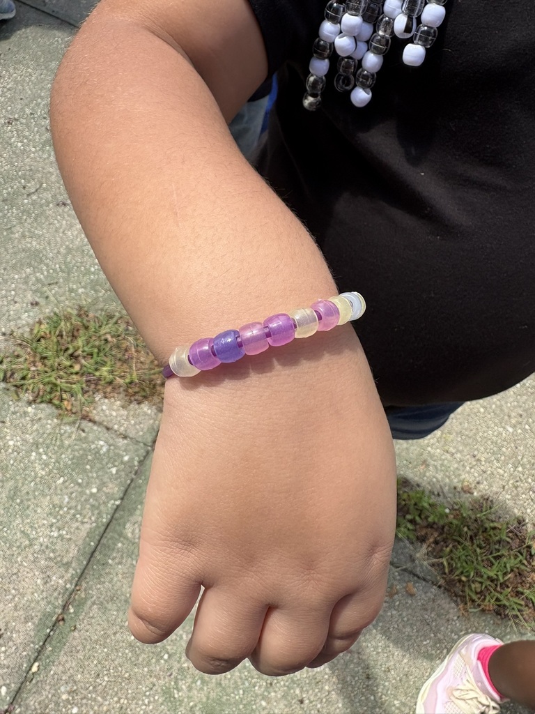 Student wears a bracelet made with color-changing magic beads.