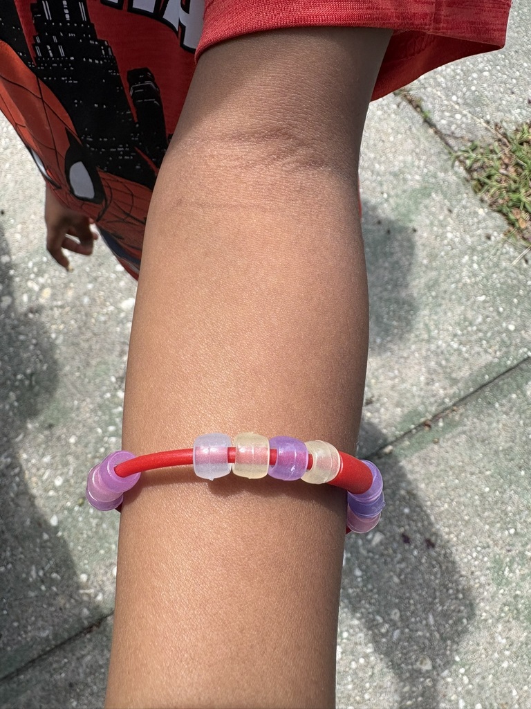 Student wears a bracelet made with color-changing magic beads.