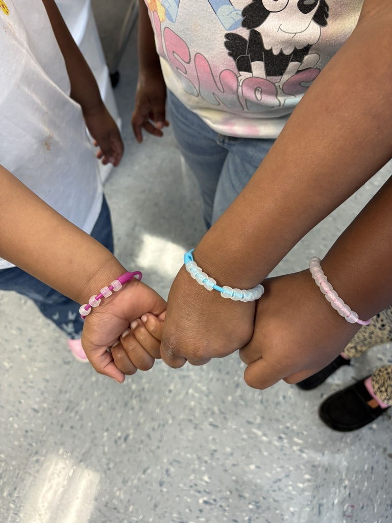 Students show off their colorful magic bead bracelets together.